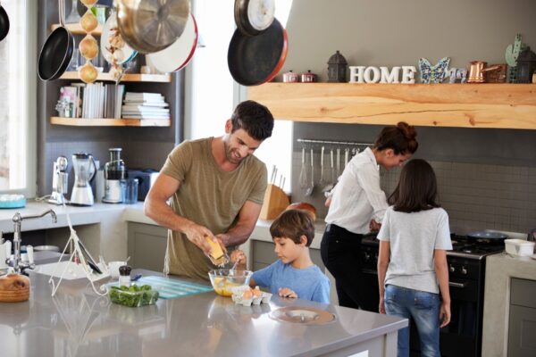 Family In Kitchen Making Morning Breakfast Together